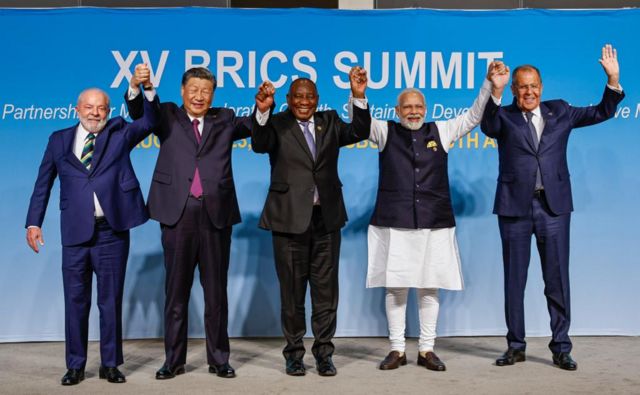 Fotografados, de mãos dadas: Lula, Xi Jinping (China), Cyril Ramaphosa (África do Sul), Narendra Modi (Índia) e Sergey Lavrov (ministro de relações exteriores da Rússia)