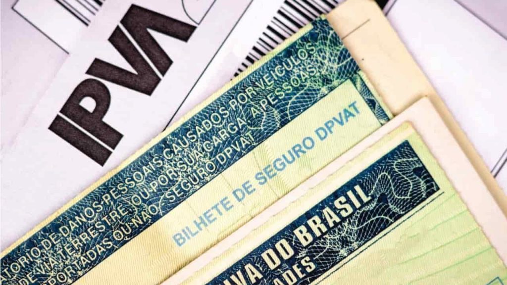 Boleto IPVA junto a um bilhete de seguro DPVAT e a um outro documento